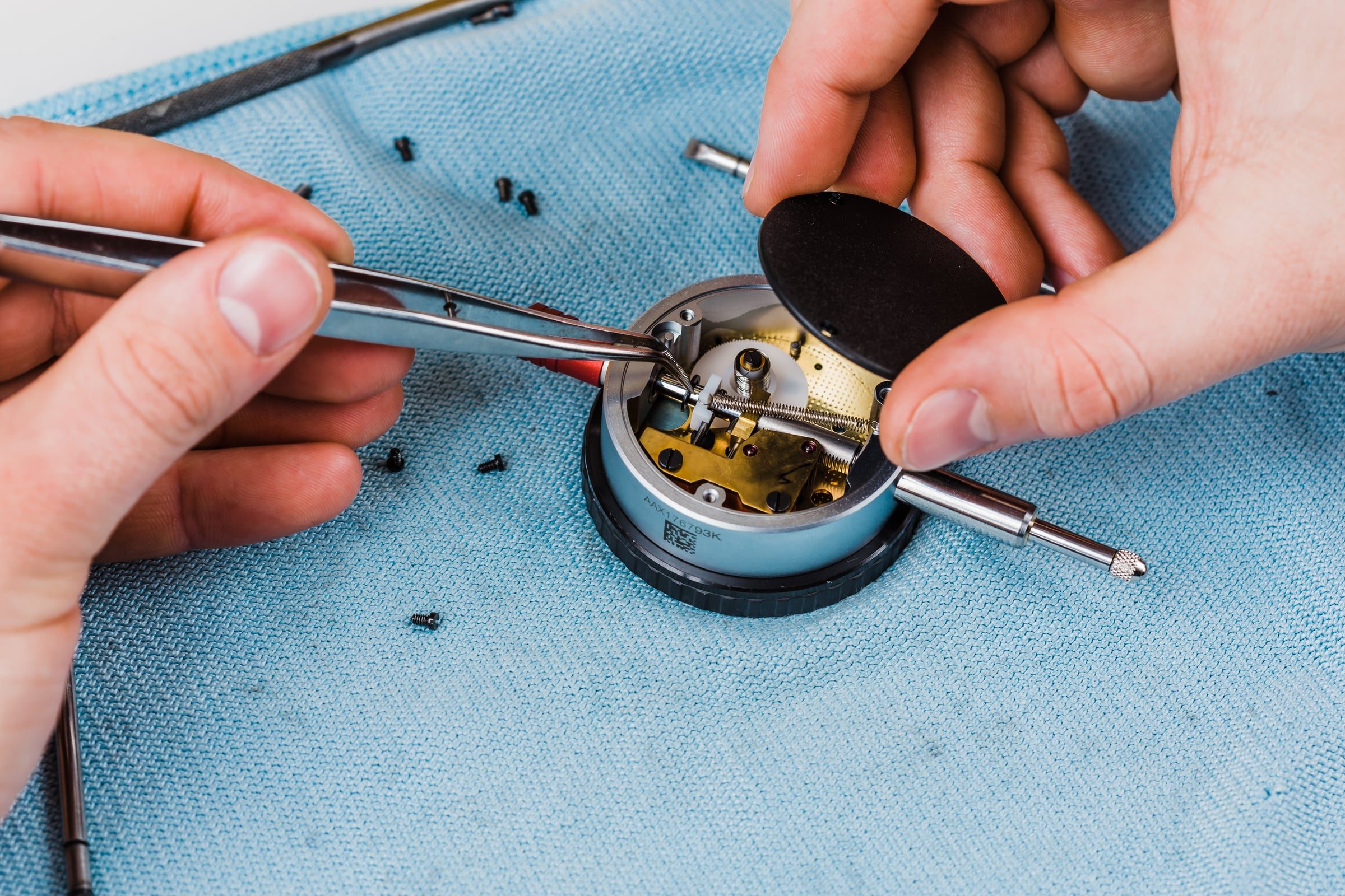 Reparatur einer geöffneten Messuhr mit Pinzette